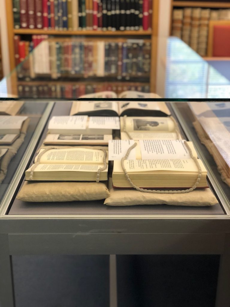 Close-up of the book display. The books are resting on cushions, with the open pages gently held down by weights.